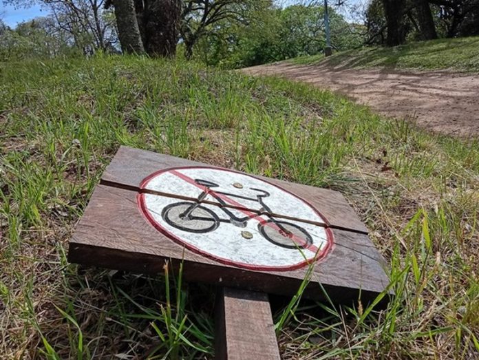 Parque San Carlos: el cartel arrancado que enciende la pelea por los senderos